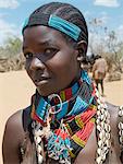 A Hamar woman at Turmi Market.The Hamar are semi-nomadic pastoralists of Southwest Ethiopia whose women wear striking traditional dress Skins are widely used for clothing and heavy metal necklaces,bracelets and anklets form part of their adornments. Cowries are also popular to embellish a woman's appearance.