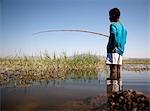 Ethiopia, Lake Awassa. A young boy fishes with a bamboo fishing rod.