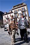 A couple in snowboarding gear walk through Chamonix,France