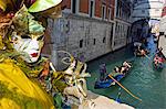 Venice Carnival People in Costumes and Masks on Canal with Gondolas