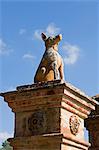 Italy,Tuscany,Petroio. A stone dog sits on top of an elegant gatepost at the entrance to a palazzo in the village of Petroio.