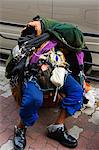 Japan,Honshu Island,Tokyo,Ginza District. Homeless tramp slumped in street.