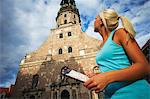 Frau blickte zu dem Turm von St. Peter, Riga, Latvi.