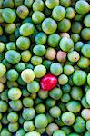 Mexico. A red fruit in a pile of limes