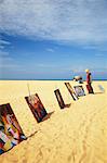 Woman looking at paintings on beach, Negombo, Sri Lank.