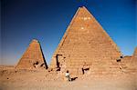 Sudan, Karima. Ein Tourist sitzt an der Basis einer alten Pyramide bei Karima.