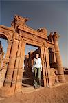 Sudan, Nagaa. A tourist stands in the doorway of a Roman temple ruin at Nagaa.