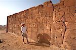Sudan, Nagaa. A tourist gazes at the hieroglyphics on the Lion Temple at Nagaa.