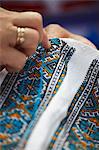 Femme couture traditionnelle motif sur le tissu au marché d'artisanat, Lviv, Ukraine