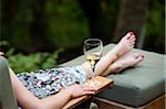 Femme reposante sur une chaise longue avec verre de vin