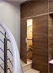 Open walnut storage cupboard on stairs with stored bicycle. Architects: WE Design - Winston Ely