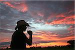 Man enjoying a drink at sunset