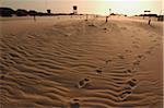 Fußabdrücke auf Sand bei Sonnenuntergang