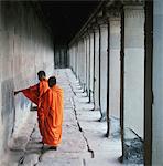 Moines bouddhistes examinant mur à Angkor Wat