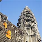 Buddhist monks climbing steps of Angkor Wat