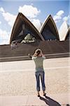 Young woman photographing Sydney Opera House