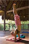 Femme faisant hand stand dans l'herbe au toit eco lodge