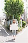 Japanische Frau hält ein Whiteboard