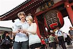 Young Couple Reading Guidebook