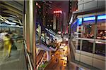 Gens en passant devant les restaurants de Soho sur l'escalator de niveaux intermédiaires pendant la nuit, Central, Hong Kong, Chine