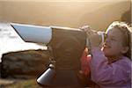 L'Angleterre, Cornwall, lézard. Une jeune fille regarde à travers un télescope au Cap Lizard, point plus au sud de l'Angleterre du continent.
