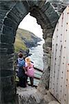 L'Angleterre, Cornwall. Garçon et fille à la porte d'entrée au château de Tintagel.