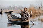 Un homme dans un bateau sur le lac Dal à Srinagar, au Cachemire, Inde