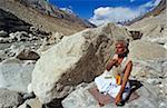 India, Uttarakhand, Garhwal, Gomukh, nr Gangotri. A pilgrim prays by the River Ganges near the snout of a glacier.