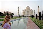 Taj Mahal, Agra, Uttar Pradesh, India. A girl gazes across the Lotus Pool towards the marble dome of the Taj Mahal.