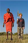 Kenya, Masai Mara.  Safari guide, Salaash Ole Morompi, with a young boy on a family safari.