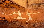 Libya, Fezzan, Jebel Akakus. A pair of running figures painted onto the walls of Uan Muhuggiag, one of Wadi Teshuinat's caves.