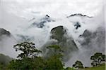 Pérou, tôt le matin, faible élévation du brouillard et les nuages des vallées abruptes qui entourent les ruines Inca de Machu Picchu.