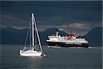 Scotland, Isle of Mull. A ferry passing a moored yacht in the Sound of Mull enroute to Tobermory on the Isle of Mull.