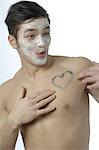 Man with facial mask and painted heart on his breast