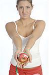 Femme tenant la pomme avec le ruban à mesurer