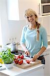 Trancher les tomates dans la cuisine de femme
