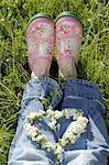 Woman lying in grass with flower wreath on her legs