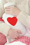 Woman holding hot water bottle with heart-shaped imprint