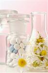 Camomile blossoms and tablets in medicine bottles