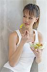 Femme en vêtements de sport manger salade
