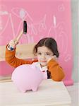 Girl with hammer and piggy bank