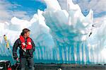 Antarctica, Antarctic Penisula, Paradise Harbour, a zodiac driver, Mark Hannaford, examines the grounded 'growler'