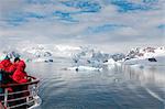 Antarktis, Antarktische Halbinsel, Paradise Harbour, Touristen, gekleidet in Antarctic einheitliche beobachten, wie das Schiff Paradise Harbour fährt.