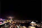 Sydney, Australien. Das Opernhaus und die Harbour Bridge bei Nacht, während in der Ferne Blitzeinschläge beleuchtet.