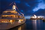 Australia, New South Wales, Sydney.  Luxury yacht at Campbells Cove with the Sydney Opera House beyond.