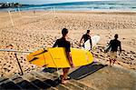 Australia, New South Wales, Sydney.  Surfers head for the water at Manly Beach.