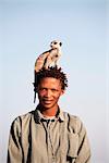 Botswana, Makgadikgadi, un bushman avec un Suricate sur sa tête.