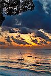 Kenia Mombassa. Ein Auslegerkanu setzt die Segel aus Diani Beach bei Sonnenaufgang.