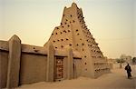 Mali, Timbuktu ou Tombouctou. Un homme se promène devant la mosquée de Sankoré du XVe siècle de la ville construite en briques de terre cuite