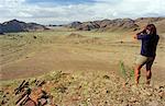 Namibia, Kaokoveld, Damaraland, Modderib Valley. Guide and tour leader Caesar Zandberg scans the Modderib River Valley